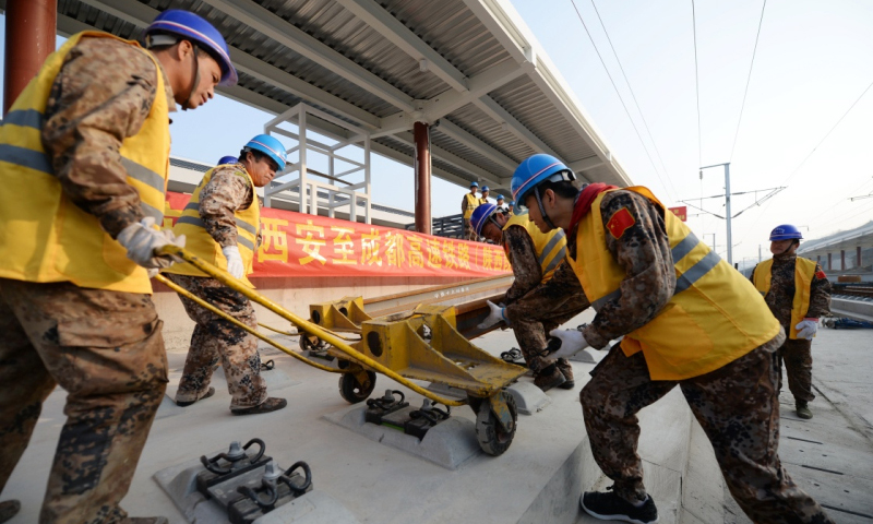 2月28日，施工人員在西成高鐵陜西段寧強南站進行鋪軌作業。（李一博 攝）