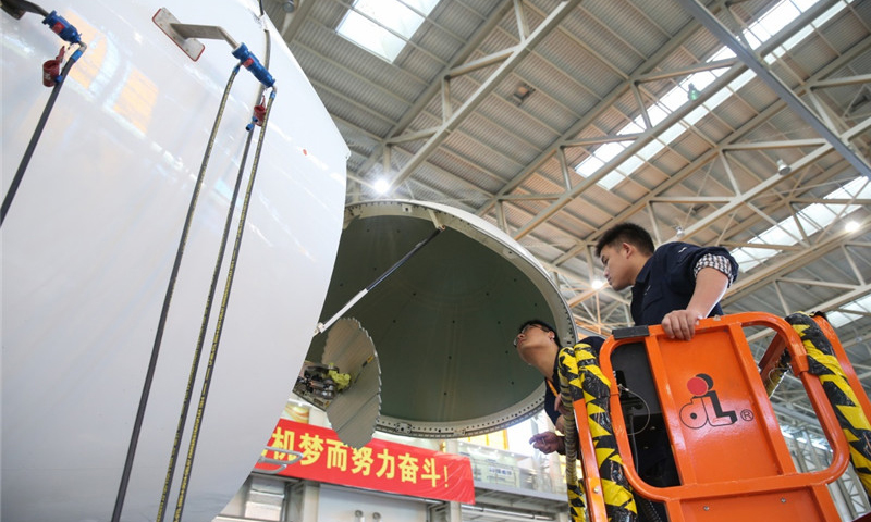 工作人員在中國商飛公司上海飛機制造有限公司總裝車間內對C919大型客機102架機進行調整工作。（新華社記者 丁汀 攝）