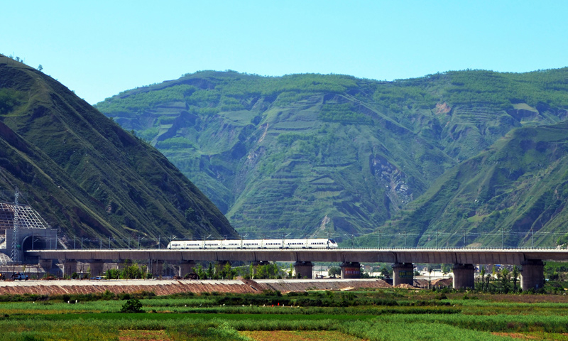 近年來，中國高鐵繼續保持快速發展步伐，“四縱四橫”高鐵網基本成形，技術成就贏得國際聲譽，服務品質不斷攀升。中國高鐵已經成為一張見證時代發展的名片。2017年7月9日，一列高鐵列車行駛在寶蘭高鐵甘肅天水段南河川大橋上（武龍 攝）。