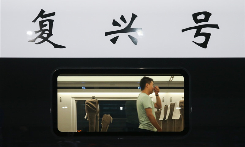 6月26日，在上海虹橋火車站，乘客在“復興號”G124次列車內行走。（新華社記者 丁汀 攝）