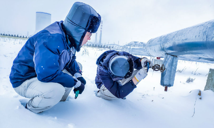 近日，北方地區普降大雪，氣溫驟降。國家能源集團相關單位積極應對大雪來襲，積極保供。國華勝利電廠維護部汽機班員工檢查廠區采暖管道放水閥門。（段超 攝）