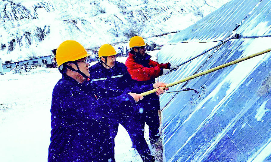 內蒙古能源項目籌建處建昌營光伏電站員工清理光伏板積雪，保障安全穩定運行。（李云濤 攝） 