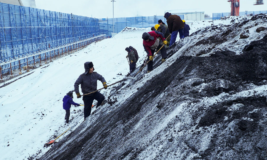 東北公司雙鴨山電廠組織員工冒雪清理煤垛，杜絕積雪和凍煤塊進入原煤斗。（隋軼英 攝）