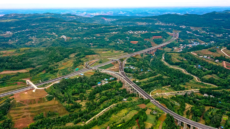 德簡高速公路位于2008年汶川地震最嚴重區域，沿線人口稠密，地形復雜，路網密集。參建人員堅持綠色環保理念施工，常態化推進生態防護，全力打造“青山綠水”工程。圖為隆興互通。
