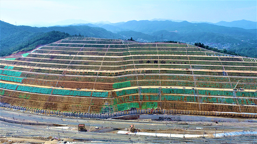 據悉，該邊坡位于渝懷鐵路增建二線懷化西編組站，其最大垂直高度124米，最大開挖寬度670米。該工程預計12月底達到開通條件。圖為高邊坡全貌。