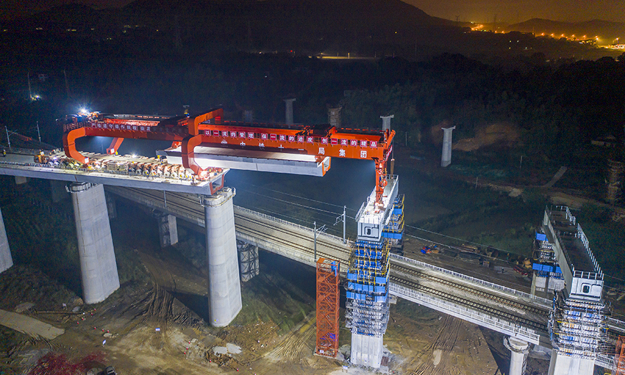 常益長高鐵正線全長約157公里，設計時速為350公里，是國家“八縱八橫”高速鐵路網的重要組成部分，是形成湖南省高鐵環線的關鍵組成部分。建成通車后，將實現湖南全省14個市州全部通高鐵的目標。圖為作業人員正在架設箱梁。（彭特 攝）