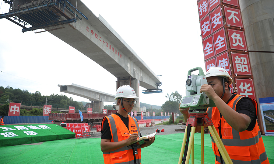 整座橋梁均位于巖溶發育地段，基礎施工難度較大，其中15號主墩位于京九鐵路路基、排水涵洞與車流量密集的G205國道“夾心地”內，現場施工條件極為有限，一度成為“卡脖子”工程。圖為技術人員進行測量。（鄧聯旭 攝）