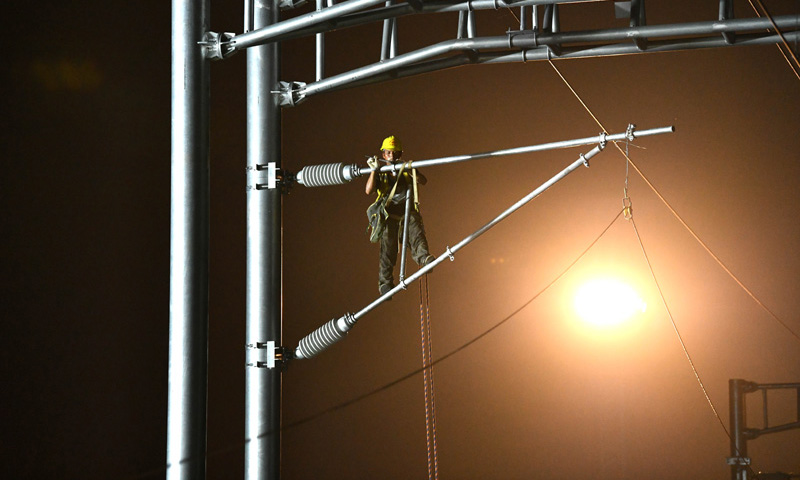 圖為9月1日凌晨，中鐵建電氣化局南方公司施工人員在合安高鐵集賢路線路所接觸網撥接現場施工。（新華社記者 劉軍喜 攝）