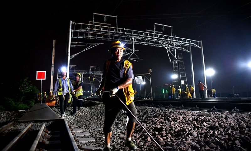 圖為9月1日凌晨，中鐵建電氣化局南方公司施工人員在合安高鐵集賢路線路所接觸網撥接現場施工。（新華社記者 劉軍喜 攝）