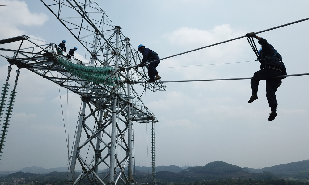 圖為參加昆柳龍直流輸電工程建設的南方電網廣東電網能源發展有限公司高空作業人員在鐵塔上展開金具安裝。（陳海東 攝）