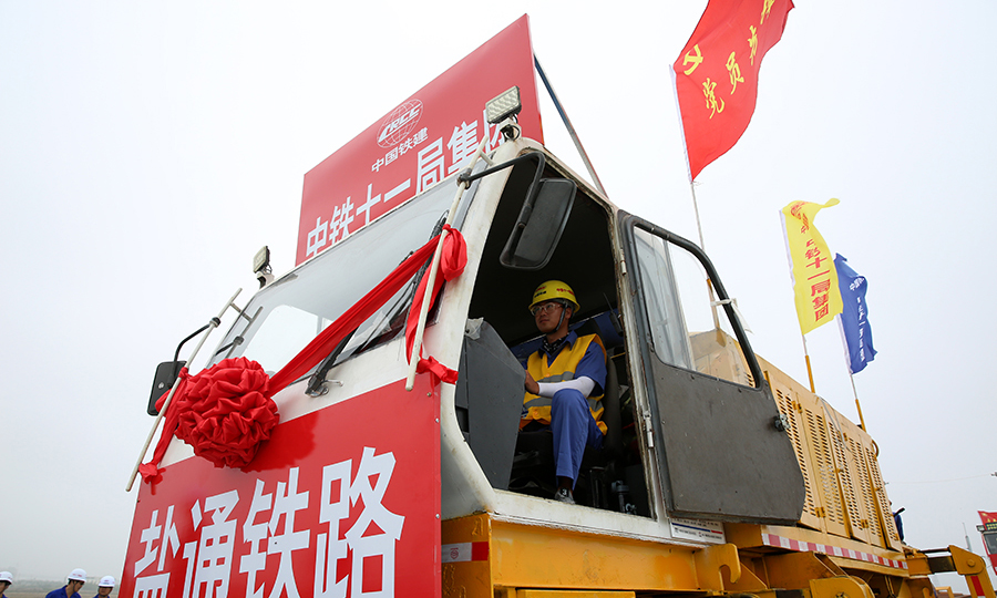 據了解，中鐵十一局鹽通高鐵鋪架項目部將采取“兩套鋪軌機+兩套長軌運輸設備”的施工組織模式，加大施工資源投入，人停機不停，雙班輪流作業，高效推進鋪軌施工，按照工期節點順利完成鋪軌任務。圖為作業人員操作鋪軌機進行500米長軌牽引作業。（彭特 攝）