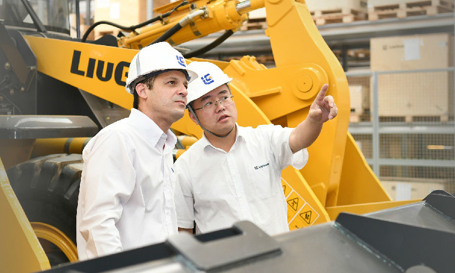  圖為近日，在巴西圣保羅，柳工巴西工廠中巴管理人員在裝配線了解設備裝配情況。