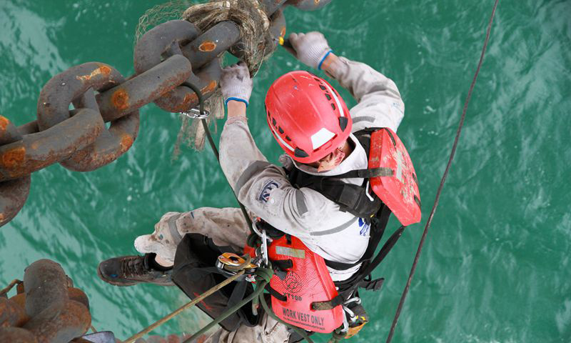 10月16日，“海洋石油921”號鉆井平臺進行鉆井作業，面對頻繁拖航作業帶來的安全挑戰，平臺積極組織專業人員對拖航作業所需龍須鏈進行探傷檢測。海油人與“龍”共舞，爭分奪秒增儲上產。圖為作業現場。