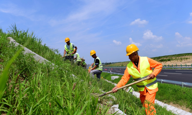圖為7月9日，工人在京哈高速長春至拉林河段進行綠化和引水道清理工作。（新華社記者 林宏 攝）