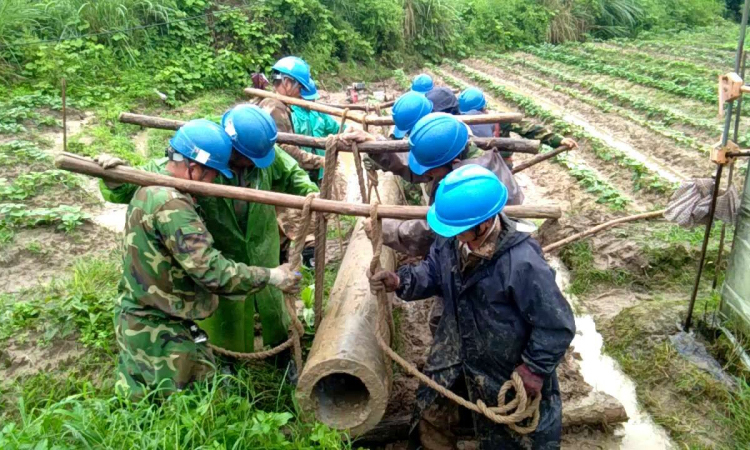 圖為6月9日，福建清流縣嵩溪鎮10千伏各溪線出現倒桿斷線。搶修時，供電員工決定人工搬運新電桿，避免破壞村民菜地。