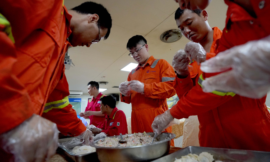 圖為5月24日，員工們在工作之余到食堂幫廚，一起包餃子。（新華社記者 王毓國 攝）