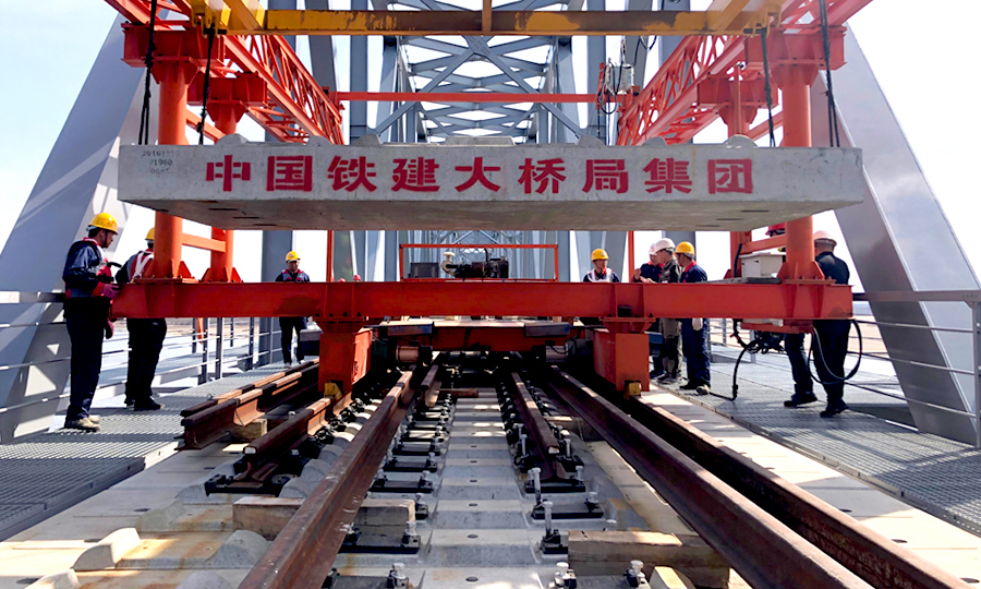 同江中俄鐵路大橋是中國首座跨境四線套軌板式無砟軌道鐵路大橋，可適應中俄兩國不同規格的軌距。大橋無砟軌道板為四線套軌板式結構，俄方軌距線路在左為1520mm，國內軌距線路在右為1435mm，兩者相差85mm。該板型為國內外首次采用。圖為中國鐵建大橋局四公司同江中俄鐵路大橋項目中俄交界最后144米鋪軌。