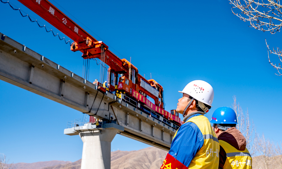 為安全架設拉林鐵路聲屏障橋梁，該項目部組建專業檢修隊伍，對架橋機進行全面、系統地檢修，確保橋梁自重增大后，架橋機能安全順利的架設橋梁。圖為現場安全員在橋下檢查架設情況。