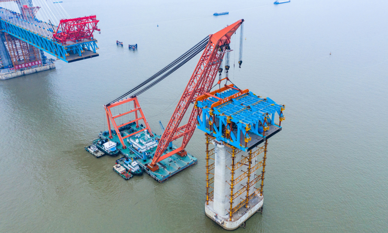 1月29日，由中鐵大橋局承建的滬通長江大橋27號輔助墩第3段節間鋼梁吊裝對接成功，標志著主航道橋墩頂鋼梁架設施工全部完成。圖為吊裝施工現場。