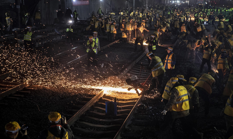 西安火車站改擴建工程于2015年正式啟動，采取“邊行車、邊建設”的施工方案，屬全國省會城市改造難度相對較大的車站，也因此被形象地稱為“在鐵路樞紐心臟上做手術”。圖為1月15日凌晨，中鐵十一局施工人員在西安站改擴建工程現場緊張施工。（新華社記者 陶明 攝）