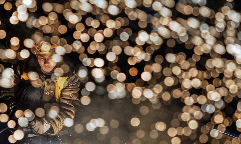 圖為1月15日凌晨，中鐵十一局施工人員在西安站改擴建工程現場切割鋼軌。（新華社記者 陶明 攝）