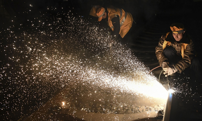圖為1月15日凌晨，中鐵十一局施工人員在西安站改擴建工程現場切割鋼軌。（新華社記者 陶明 攝）