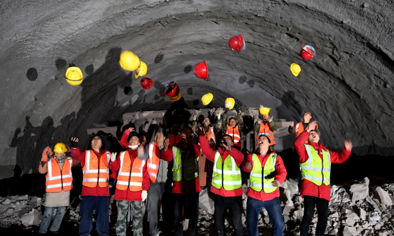 圖為12月26日，工程建設者在施工現場慶祝隧道貫通。（新華社記者 朱祥 攝）