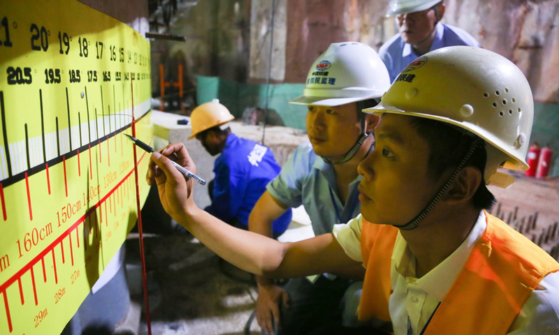 據悉，亭洪路延長線預計將于年內建成通車，屆時將大幅緩解區域擁堵情況，改善江南片區交通路網狀況，為廣西壯族自治區成立六十周年獻禮。圖為技術人員監控轉體角度。（鄧聯旭 攝）