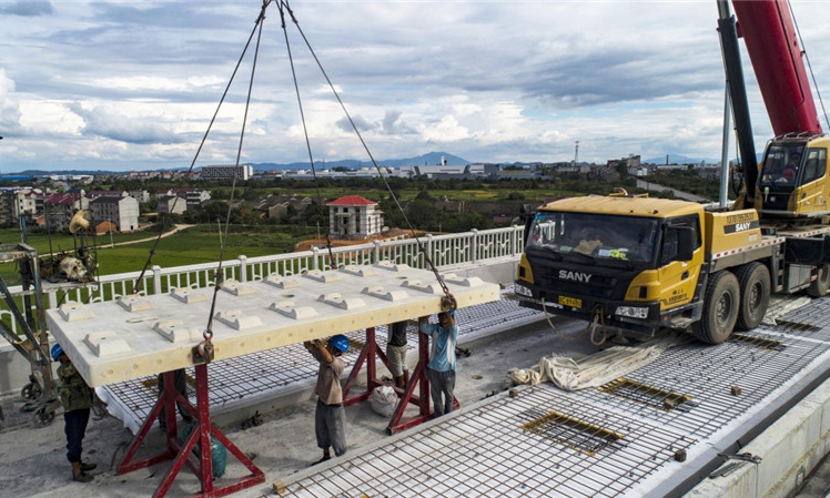 圖為8月30日，中鐵十一局職工在江西省豐城市境內的昌贛高鐵孫渡特大橋上吊裝無砟軌道板。（新華社記者 杜華舉 攝）
