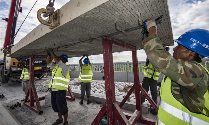 圖為8月30日，中鐵十一局職工在江西省豐城市境內的昌贛高鐵孫渡特大橋上吊裝無砟軌道板。（新華社記者 杜華舉 攝）