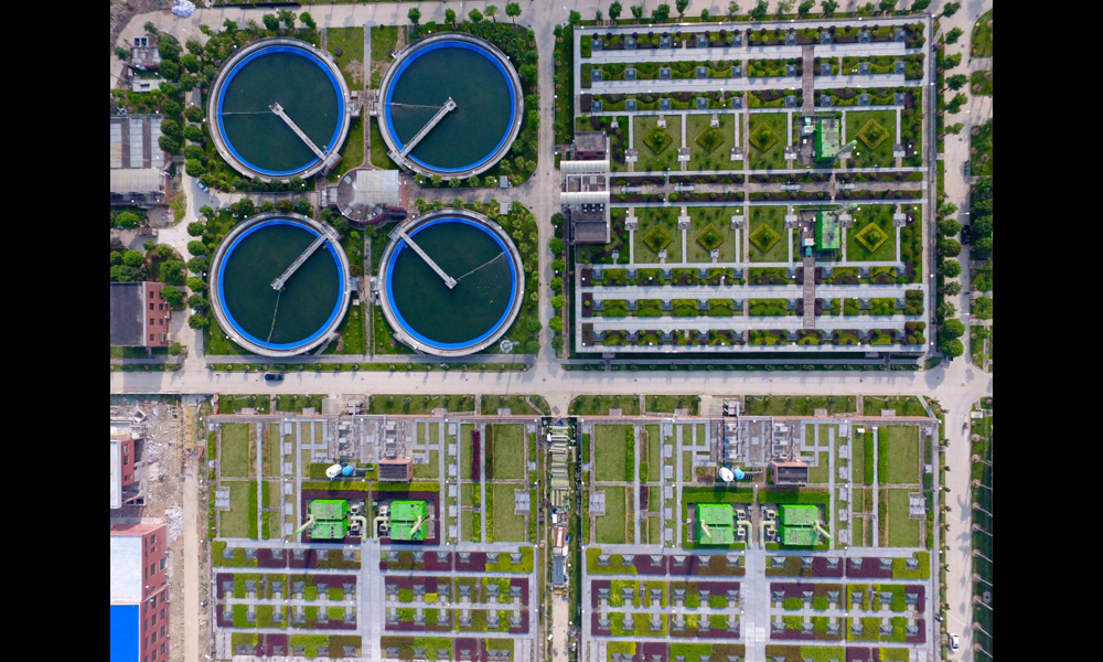 洋里污水廠位于福州鼓山南麓，擔負著76平方公里、150萬人口的污水處理任務，日處理污水60萬噸。圖為7月2日，無人機拍攝的福州洋里污水廠三期二次沉淀池和頂層綠化的生物反應池。（新華社記者 姜克紅 攝）