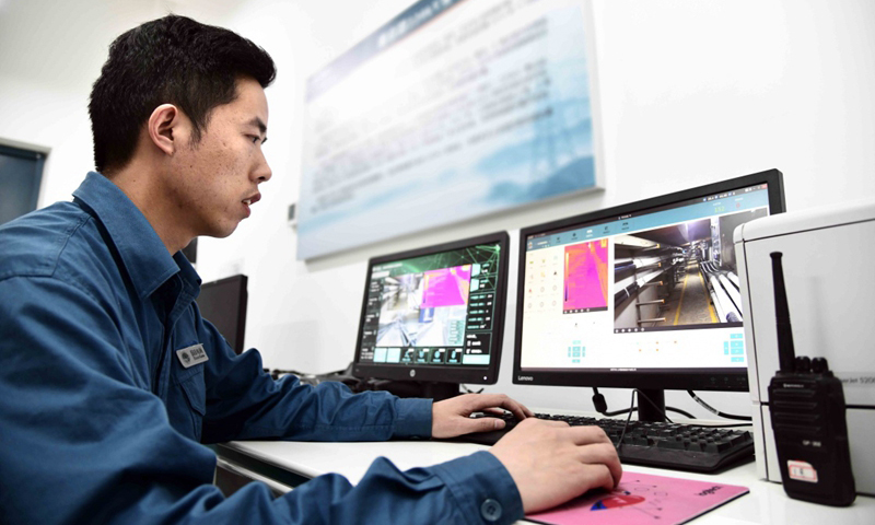 5月29日，國網青島供電公司工作人員通過電腦遙控智能巡檢機器人對地下電纜進行數據采集。（新華社記者 郭緒雷 攝）