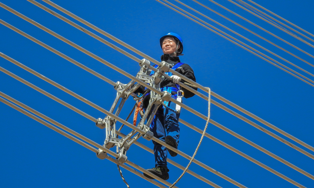 蒙東電力檢修公司錫林浩特輸電運檢分中心女子特高壓輸電班成立于2016年7月，前后招收兩批共10名女員工，她們中有一半來自其他省份，都是“90后”。兩年來，姑娘們以不甘無為、自強自立、勇于進取的精神，在人煙罕至、氣候嚴酷的茫茫荒野上挑戰著特高壓“禁區”。王林夢在1000千伏特高壓勝錫線線路上進行走線驗收。（作者：李廣杰）