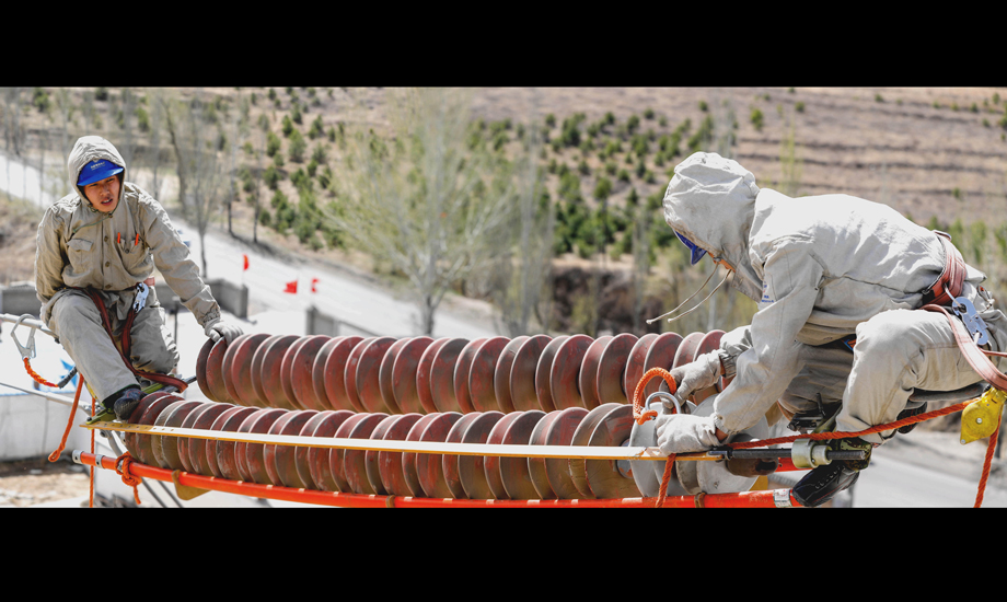 4月10日，薛家灣供電局輸電管理處對220千伏萬楊線相關塔基進行帶電更換RTV瓷質絕緣子作業。（作者：周京津）