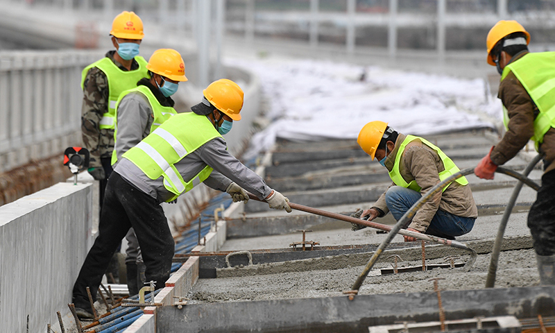 春節期間，5500余名參與建設我國首條民營控股高鐵——杭紹臺鐵路的員工堅守崗位就地過年，工人們利用晴好天氣奮戰在工地上，穩步推進工程進度。圖為2月17日，杭紹臺鐵路中鐵三局參建工人在位于浙江紹興上虞區境內的紹興特大橋進行軌道底板澆筑施工。（新華社記者 黃宗治 攝）