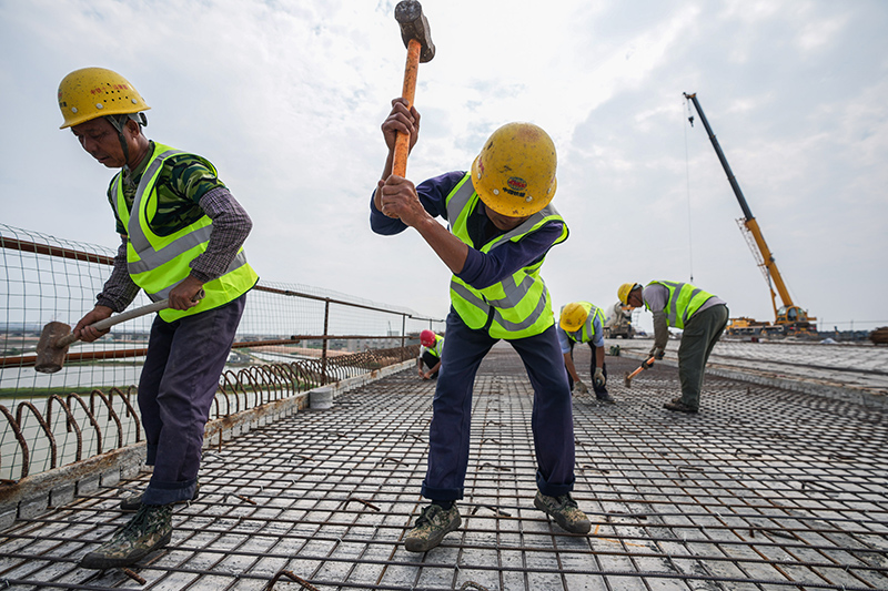 圖為5月1日，工人在珠海鶴港高速公路二期工程高欄港樞紐立交橋建設現場施工。（新華社記者 劉大偉 攝）