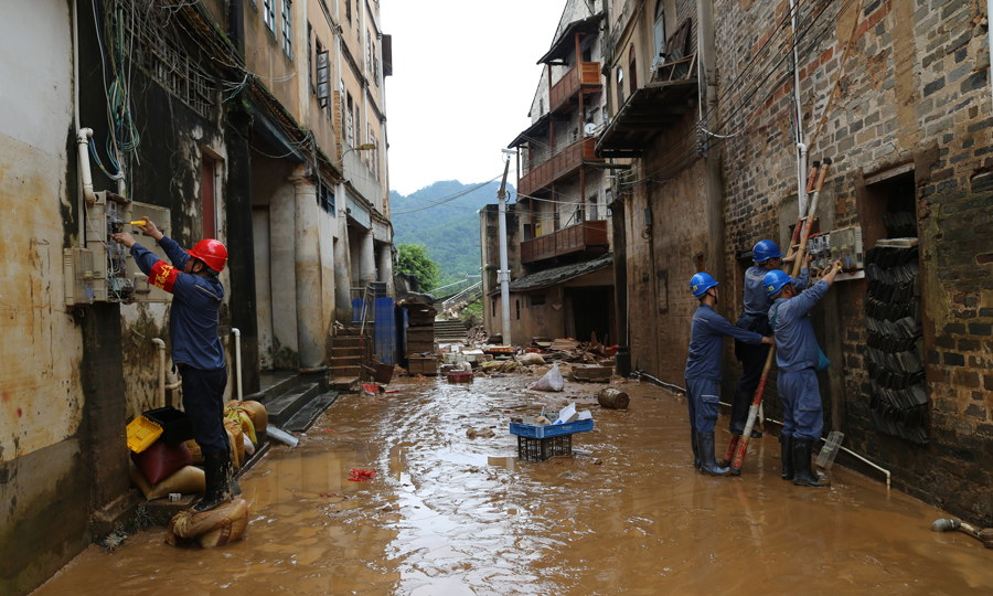 6月18日，廣東梅州大埔茶陽鎮的洪水逐漸退去，為盡快恢復當地的供用電正常，南方電網廣東梅州大埔供電局茶陽供電所工作人員深入受災現場，在落實好現場安全措施后，對故障電表進行檢修、更換。郭麗燕 攝