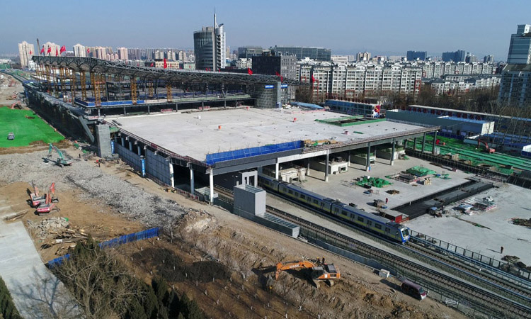 日前，北京地鐵13號線在上地站與西二旗站之間改線成功，由京張高鐵清河站站房外轉入站房內運行。圖為2月20日，地鐵列車通過建設中的京張高鐵清河站。新華社發（馮凱 攝）