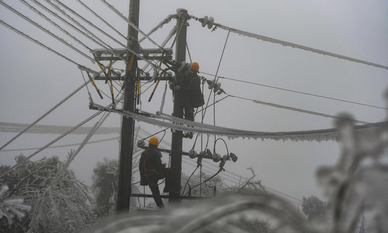 圖為2月20日，電力工人黃通（右）和王放暉在新化縣郭家村進行搶修作業。（新華社記者 薛宇舸 攝）