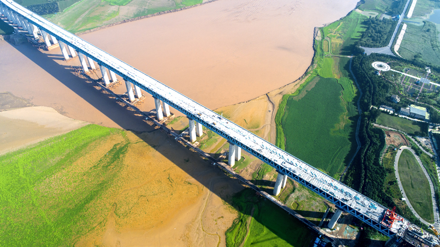 浩吉鐵路一跨長江，兩跨黃河，依次跨越漢江、長江、洞庭湖和贛江等水系。全線建設700多座大中橋，其中5公里以上特大橋有10座，洞庭湖特大橋、龍門黃河大橋等為全線重點控制性工程。圖為中國鐵建大橋局承建的三門峽黃河公鐵兩用大橋，該橋為連續鋼桁梁橋，其中鋼桁梁頂推創下長度、重量兩項世界之最。