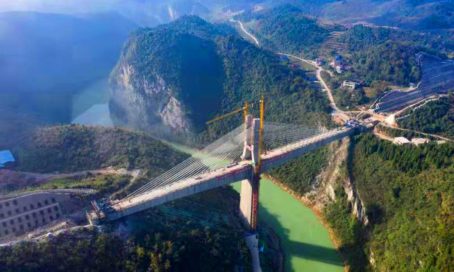 黔張常鐵路是國家鐵路網渝（重慶）長（沙）廈（門）快速鐵路的重要通道，西起重慶黔江，東至湖南常德，全長336公里，設計時速200公里，90%以上地處武陵山區，沿線穿越深山峽谷、溶洞密集、暗河遍布。圖為航拍中鐵十一局施工的黔張常鐵路長灣澧水大橋。（徐云華 攝）