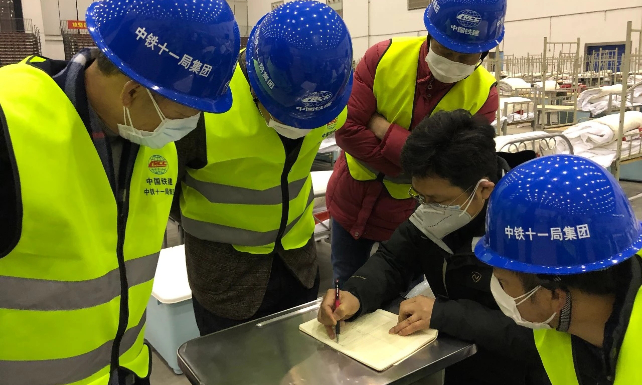 2月5日下午4時20分許，中國鐵建所屬中鐵十一局繼馳援武漢火神山醫院、武漢國際會展中心、武漢客廳“方艙醫院”后，再次接到增援通知，武漢客廳“方艙醫院”施工還需要支援。接到通知后，中鐵十一局火速集結160多名工人，帶著電鉆、電鋸等簡易工具和物資緊急馳援。圖為分配工作任務。