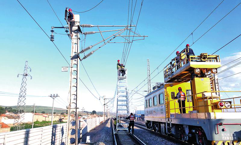 由于近期機車高位運行，取流大，國家能源集團包神鐵路集團神朔鐵路公司三岔站區供電車間同時使用軌道車、梯車、人工作業，對上網點、并網點、關節電聯接主導電回路進行專項檢修整治，成立干部包保小組，扎根一線檢查督導“天窗”集中修全過程，確保“天窗”集中修期間對接觸網主導電回路檢修有序可控。圖為7月14日，接觸網檢修現場。