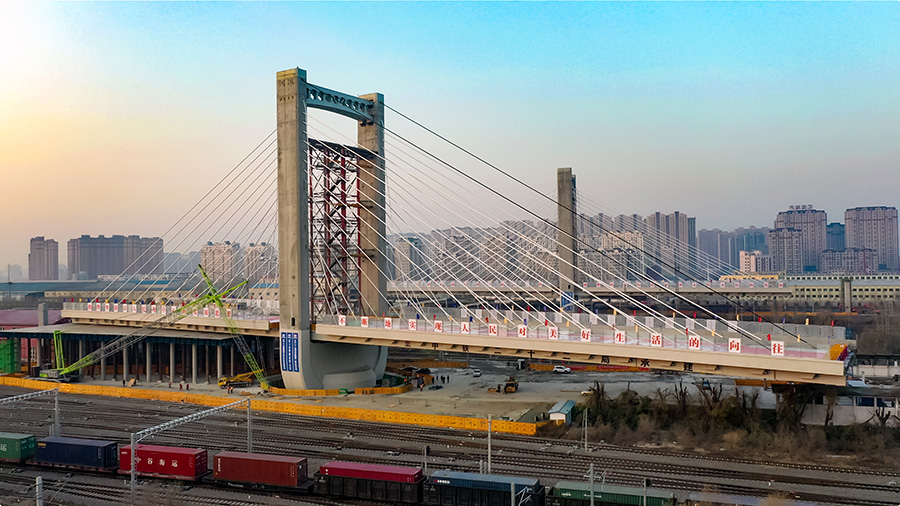 這座橋梁長843米、寬30米，雙向6車道，為混凝土現澆連續梁結構，上跨哈爾濱鐵路局管內最大路網性編組站哈爾濱南站的48條鐵路既有線和1條市政主干道，主跨長198米，兩側邊跨各長118米，兩座主塔高73.7米。圖為緩緩轉動的哈西大橋主塔和連續梁。