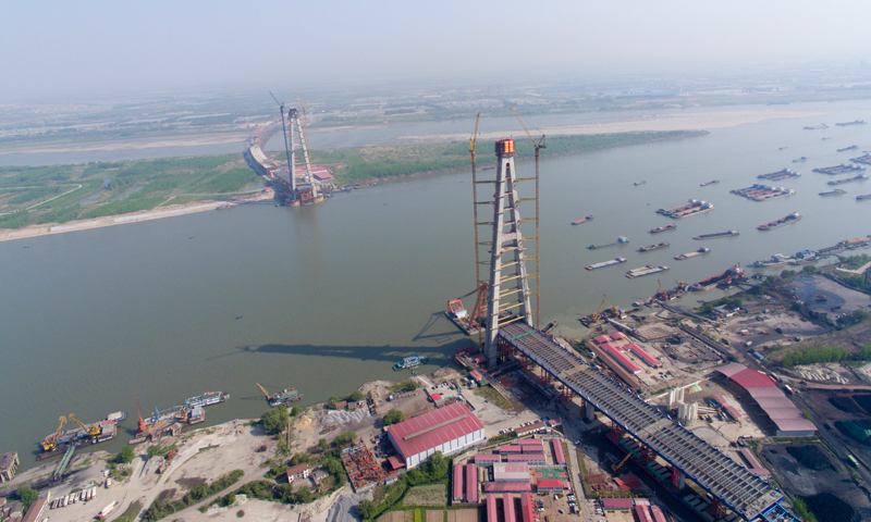 這也標志著由中鐵大橋院設計、中鐵大橋局施工的世界上跨度最大的雙塔鋼箱及鋼箱結合梁斜拉橋建設取得階段性勝利。圖為4月10日，武漢青山長江大橋南岸主塔成功封頂（無人機拍攝）。